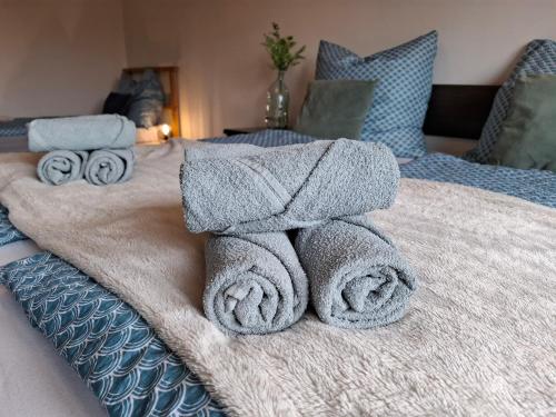 a pile of towels on a bed at Ferienwohnung See und Sonne in Obing