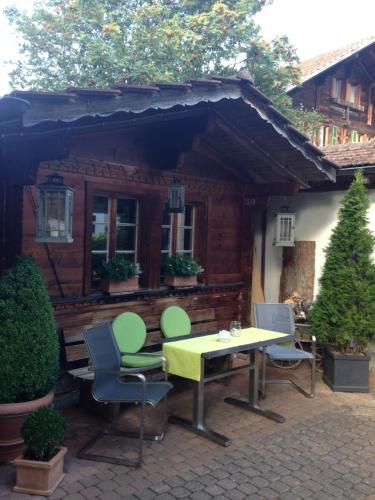 a table and chairs in front of a cabin at Ferienwohnung Milchgaessli in Frutigen