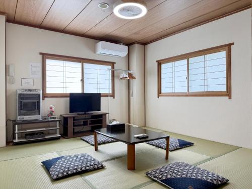 a living room with a table and a tv at lodge EDMONTON in Yuzawa