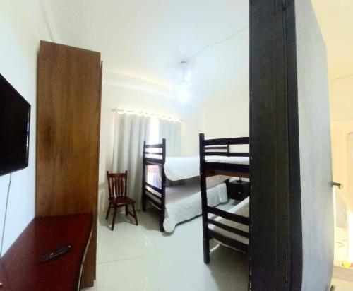 a bedroom with two bunk beds and a mirror at Suites e Cia - Pousada in Volta Redonda