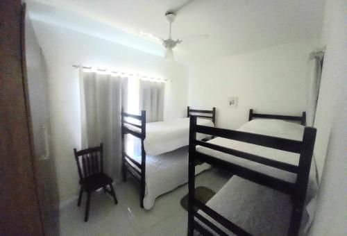 a room with two bunk beds and a chair at Suites e Cia - Pousada in Volta Redonda