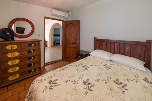 a bedroom with a bed and a dresser and a mirror at Hotel Casa Grande in Taxco de Alarcón