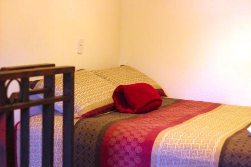 a bedroom with two beds and a red backpack on the bed at Chalé Cabana Rústico refúgio e sossego há 1,5km do centro de Domingos Martins in Domingos Martins