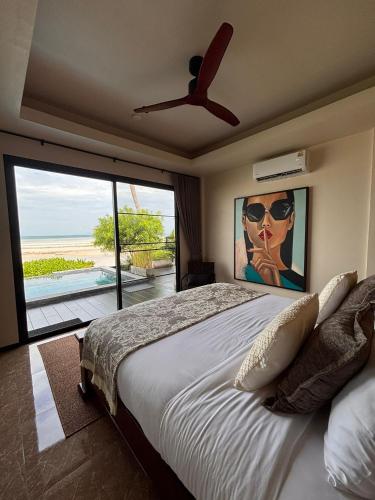 a bedroom with a bed with a painting of a woman with sunglasses at Villa Manolo in Ban Bang Makham