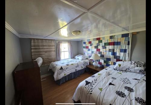 a bedroom with two beds and a window at Wolf Cove Retreat House in Amherst Cove