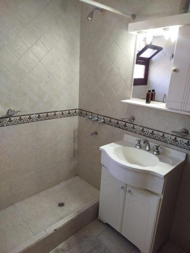 a bathroom with a sink and a mirror and a tub at COMPLEJO LLATANI in Los Reartes