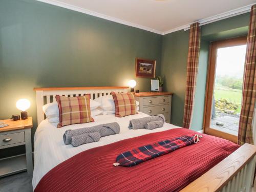 a bedroom with a large bed and a window at Puidrac Cottage in Lochearnhead