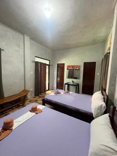 two beds in a room with hats on top of them at Cupids Cabin Beach in San Francisco