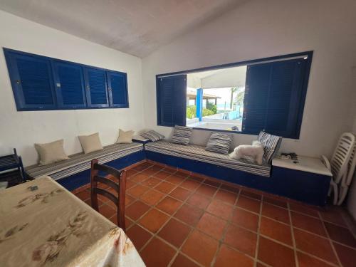 a dog sitting on a bench in a room with a window at PÉ NA AREIA EM Pirangi do Norte in Parnamirim
