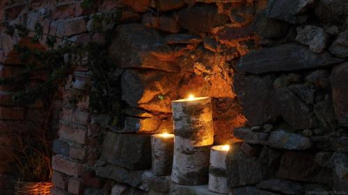 a stone wall with candles in front of a fire at Kap Café in Kaplice