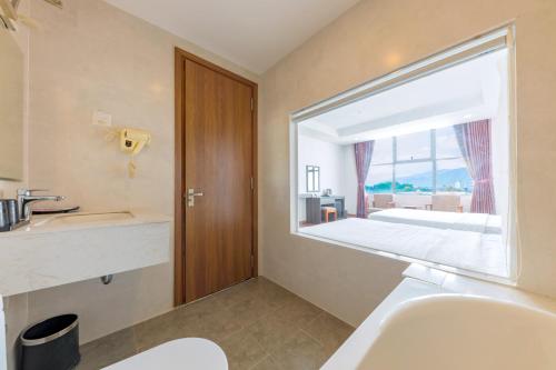 a bathroom with a sink and a large window at Dolphin Bay Hotel Nha Trang in Nha Trang