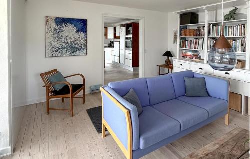 a living room with a blue couch and a chair at 2 Bedroom Nice Apartment In Vejle Øst in Bredballe