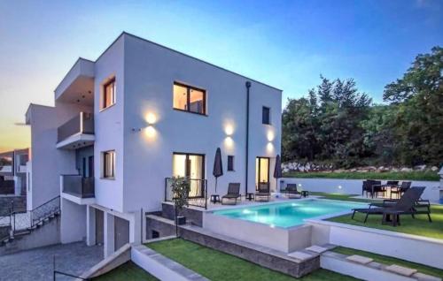 a large white house with a swimming pool at Beautiful Home In Kostrena in Kostrena