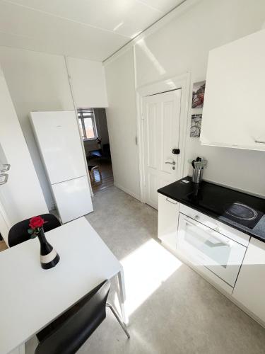 a kitchen with white cabinets and a black counter top at Beautiful 2 Bedroom Apartment on Borgergade in Aalborg