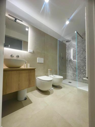 a bathroom with two sinks and a toilet and a shower at MP home in Le Grazie