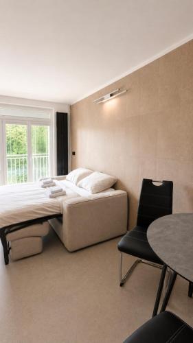 a bedroom with a bed and a chair and a table at Košice Kysucka Apartment in Košice