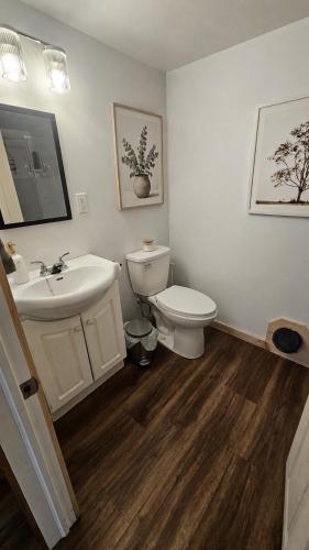 a bathroom with a white toilet and a sink at Modern Two Bedroom Basement Apartment in Saint John