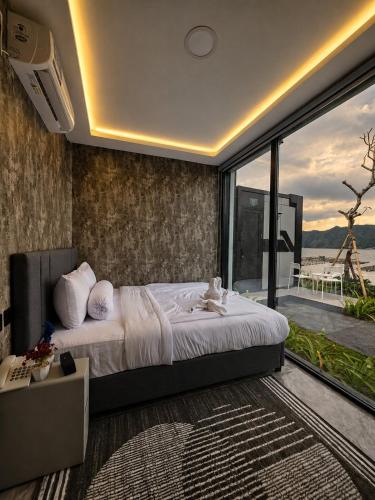 a bedroom with a large bed and a large window at montevela glamping kintamani in Kubupenlokan