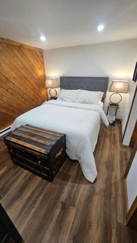 a bedroom with a large white bed with a wooden floor at Modern Two Bedroom Basement Apartment in Saint John