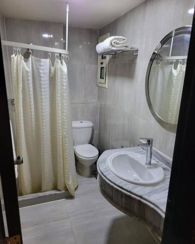 a bathroom with a sink and a toilet and a mirror at Porto Sokhna Marina Towers sea view in Ain Sokhna