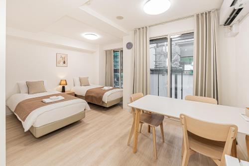 a hotel room with two beds and a table at 直达池袋丨东京丨银座无需换乘丨地铁站步行3分钟 丨商店街旁 生活出行方便 in Tokyo