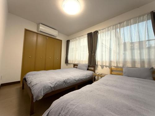 a hotel room with two beds and a window at STAY3‐11 in Asahikawa