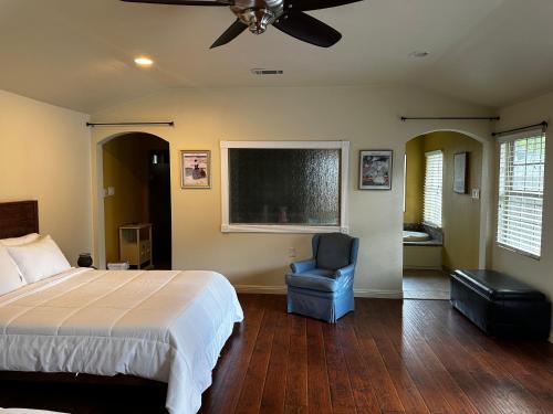 a bedroom with a bed and a chair and a tv at Madeira Suite in Fort Worth