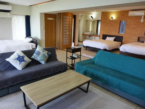 a living room with a couch and a bed at 熱海 天空のホテル 夢寿庵-Mujuan- in Atami