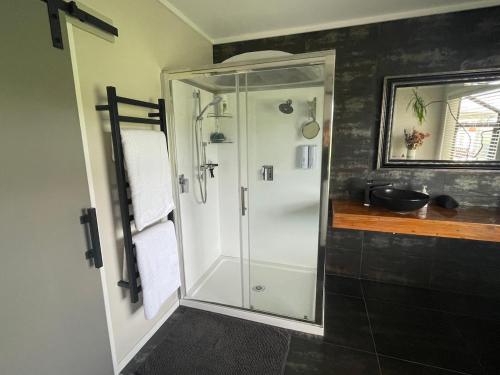 a shower with a glass door in a bathroom at Rural Stay On City Doorstep in Palmerston North