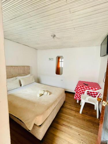 a bedroom with a large bed and a table at Hotel Colonial El Gran Fénix in Tunja