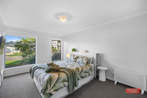 a white bedroom with a bed and a window at Getaway on Grampian 2 - 8 guests Pets allowed in Cowes
