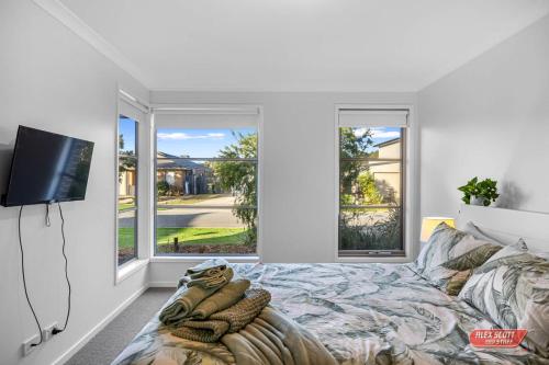 a bedroom with a bed and a flat screen tv at Getaway on Grampian 2 - 8 guests Pets allowed in Cowes