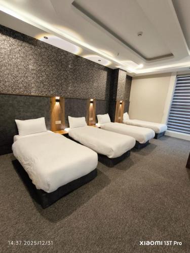 a row of four beds in a room at فندق سيوار in Erbil