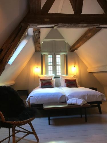 a bedroom with two beds and a window at Burgstraat 8 in Ghent