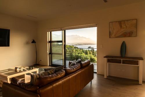a living room with a couch and a large window at Sleek, Elevated Views, Hidden - KK43103 in Kaikoura