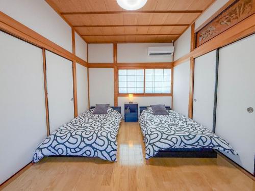 a large bedroom with two beds in it at 徳治郎の宿 in Izumi-Sano