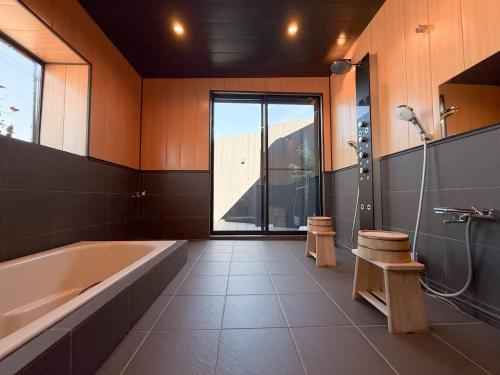 a large bathroom with a tub and a shower at 徳治郎の宿 in Izumi-Sano