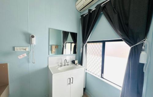 a bathroom with a sink and a window at Charters Towers Motel in Charters Towers