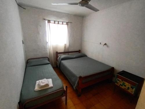 a small room with two beds and a window at Hospedaje Alicia in Barraquero