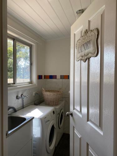 a laundry room with a washing machine and a sink at Riverstone Cottage at Murray Bridge in Murray Bridge