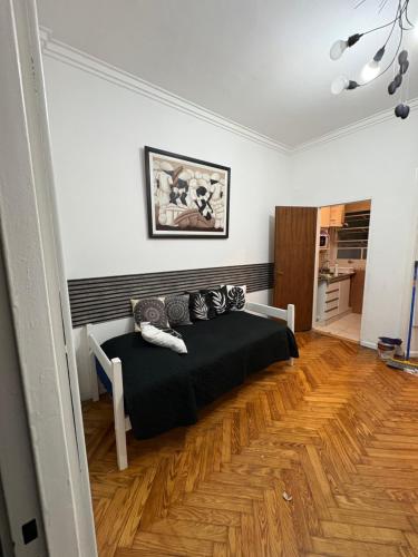 a bedroom with a bed and a wooden floor at corazón obelisco 2 in Buenos Aires
