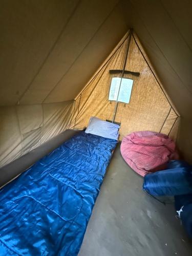 a tent with two beds and a lamp in it at Red Era Glamping in Vilnius