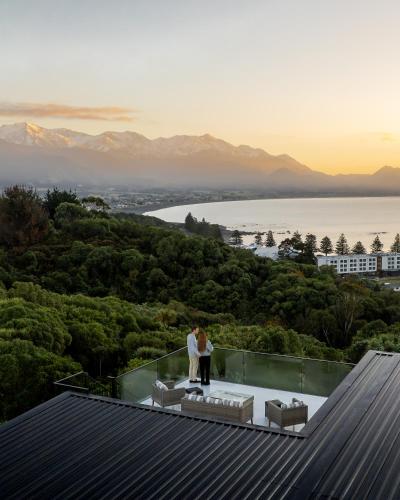 a bride and groom standing on the edge of a glass roof at Sleek, Elevated Views, Hidden - KK43103 in Kaikoura