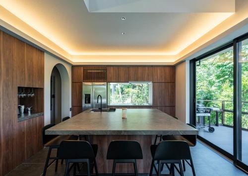 an open kitchen with a large table and chairs at REQUIES first bloom in Kawazu