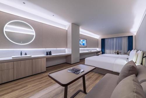 a hotel room with a bed and a sink at Crystal Orange Hotel Suzhou Xiangcheng in Suzhou
