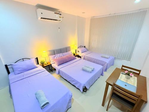 a room with two beds and a table at Lyric and Melody Collection in Santa Catalina