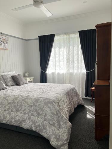 a bedroom with a bed and a window with curtains at Casa Tranquilo in Kanighan