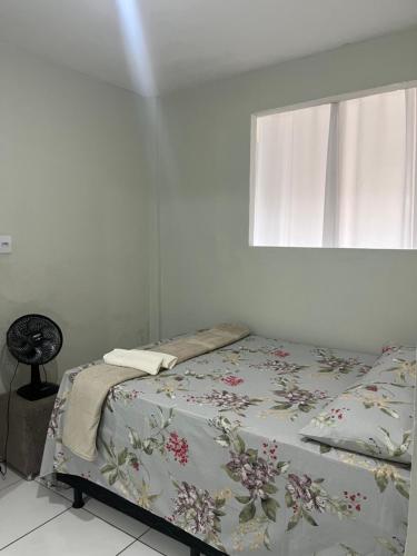 a bed in a room with a window at Casa Mobiliada in Caruaru