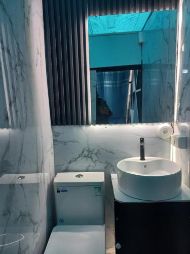 a bathroom with a sink and a toilet and a mirror at Glamping La Escapadita in Baños