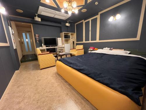 a bedroom with a large bed and a living room at ホテルQ adult only in Kashiwazaki